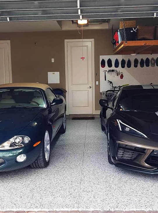 Two sports cars on a gray flake epoxy garage floor