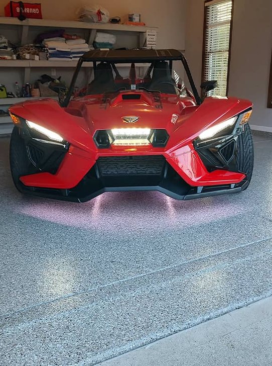 Red three-wheeled roadster on a gray flake epoxy garage floor