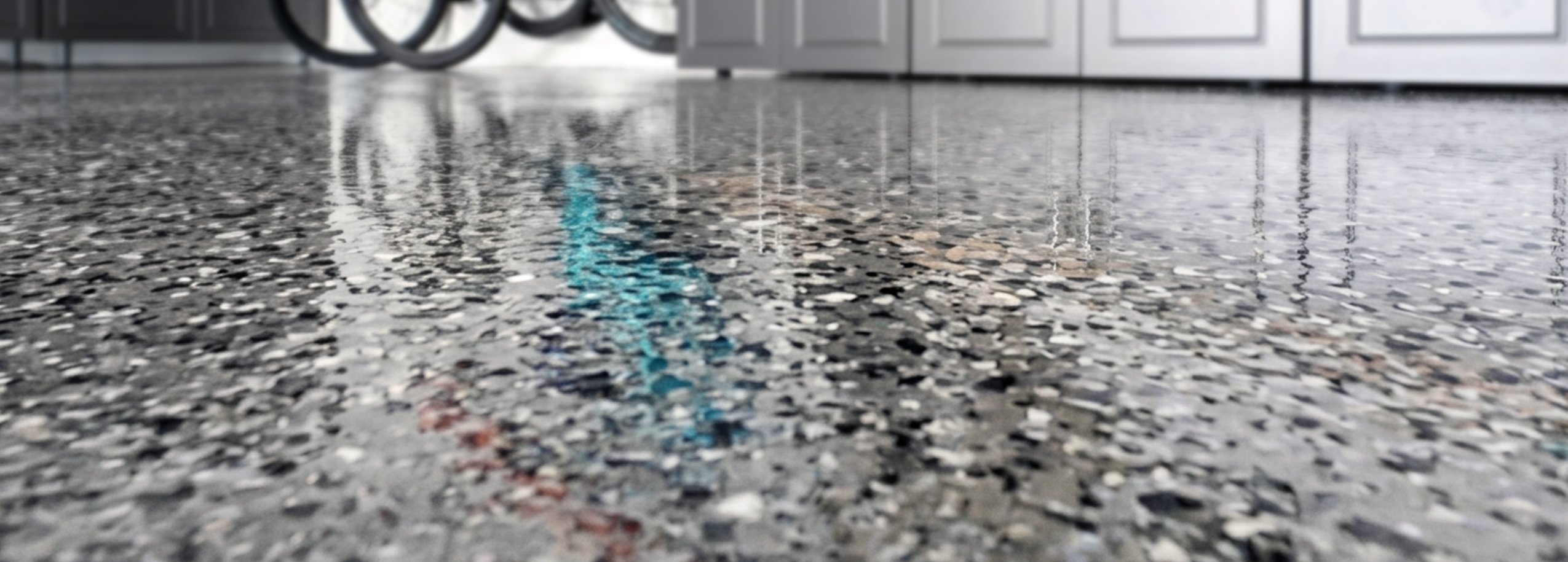 man finishing the edges of a freshly epoxy coated garage floor