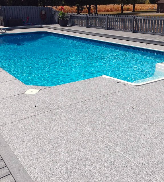 Gray flake pool-deck coating surrounding a swimming pool