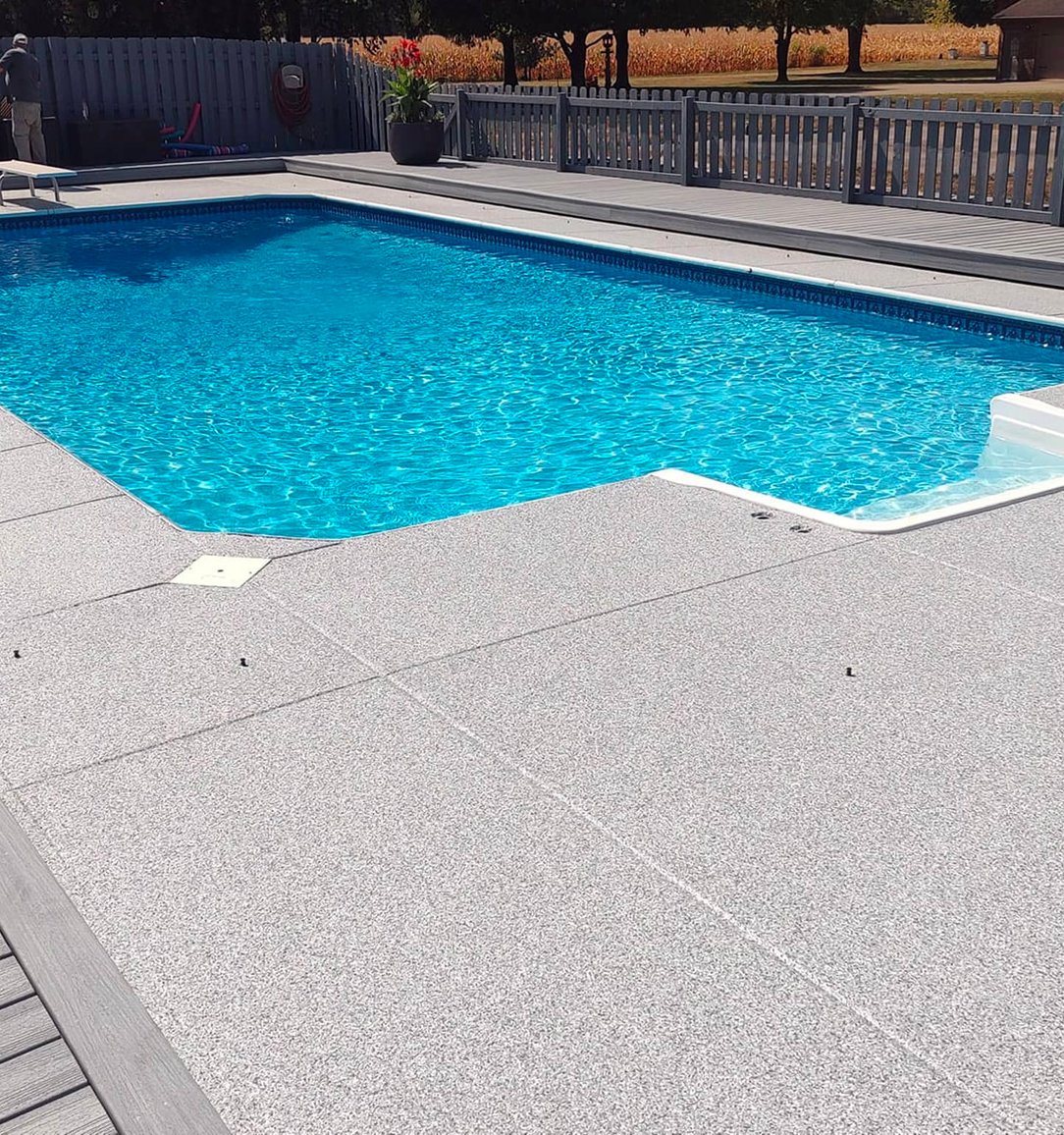 Gray flake pool-deck coating surrounding a swimming pool